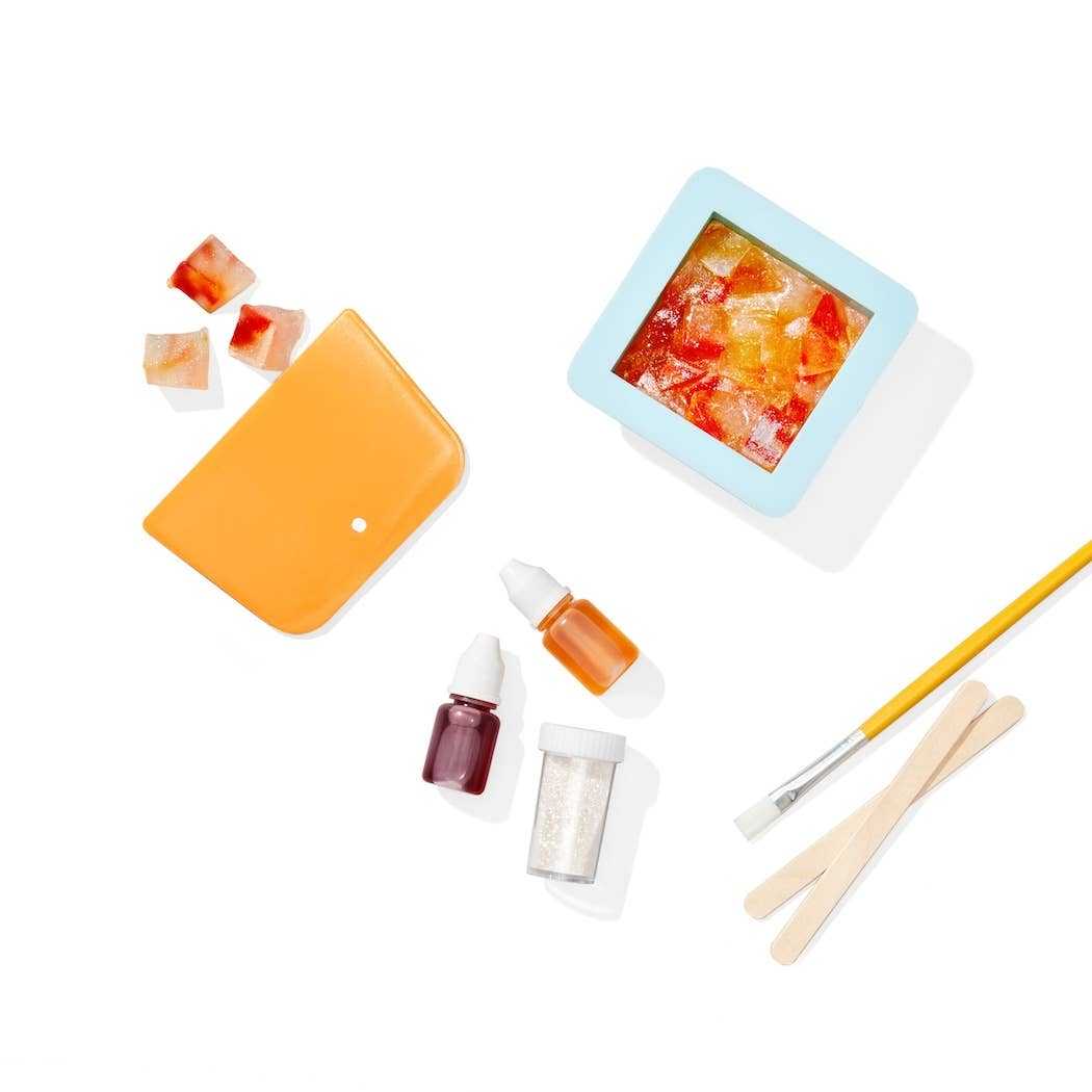 Crystal Geode Soapmaking Kit with silicone molds, liquid colors, mica powder, craft sticks, and a brush for DIY kids' soap crafting.