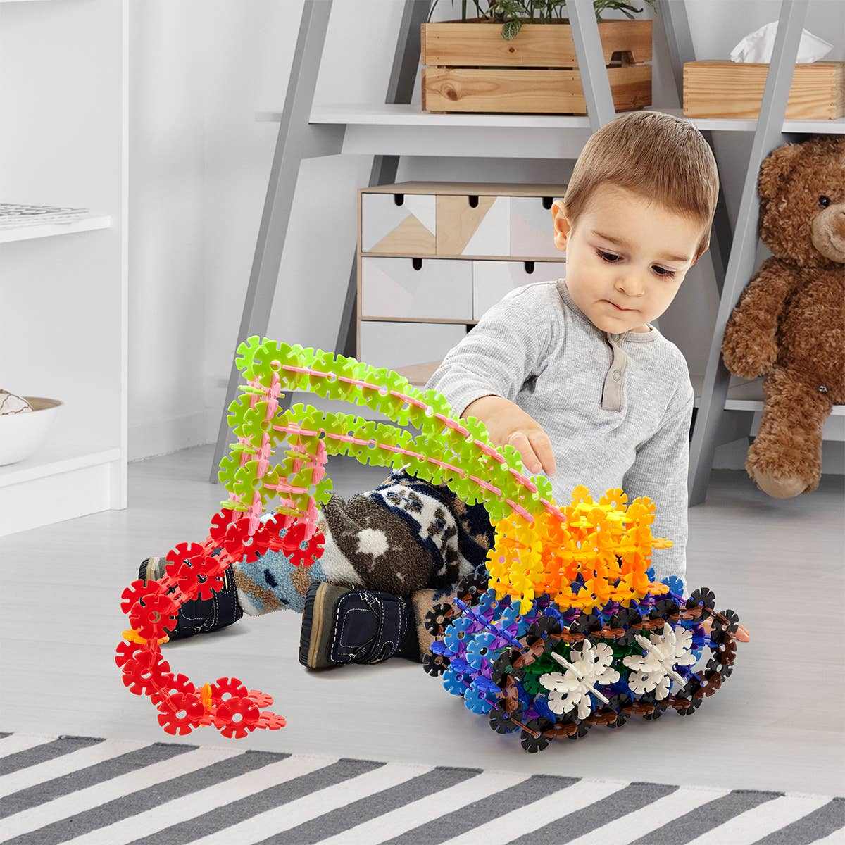 Child playing with colorful 550 piece building construction toy interlocking chips creating a vehicle in a bright playroom