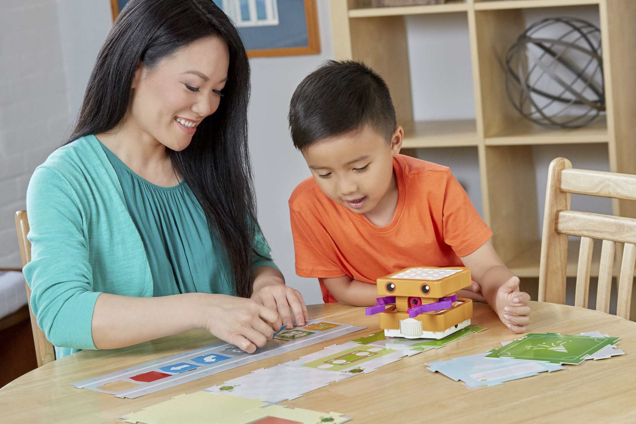Mother and son playing with Kids First coding and robotics educational robot toy on table