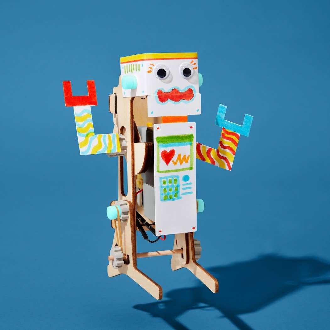 Handmade DIY jumping robot toy from STEM building kit for kids with colorful decorated wooden parts and movable arms.