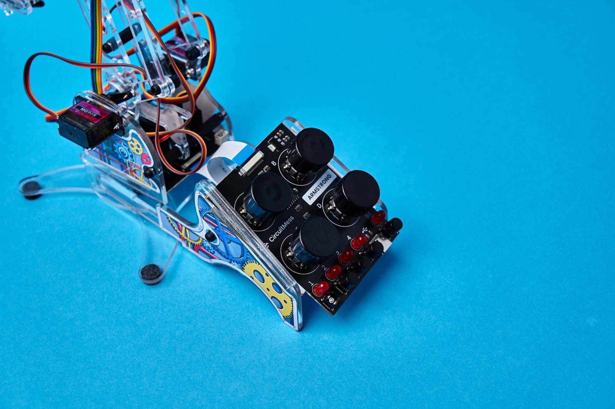 DIY color detecting programmable robotic arm kit with sensors and servo motors on blue background