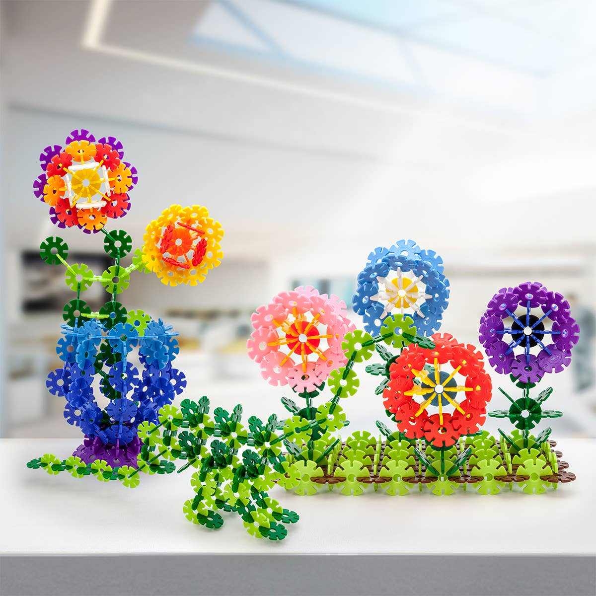 Colorful 550 piece building construction toy assembled into flower shapes with interlocking chips on table