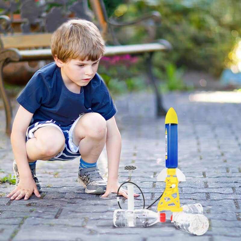Child playing with Water Powered Rocket Set on pavement.