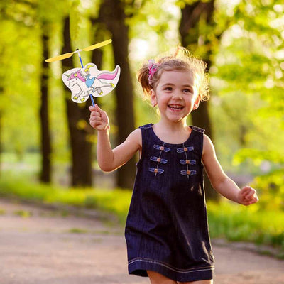 Child playing outdoors with a band powered copter featuring a unicorn princess figure