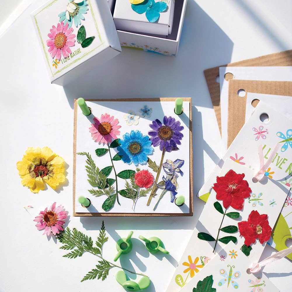Pressed flower art craft kit with colorful pressed flowers, leaves, and materials for creating trinket boxes, greeting cards, and bookmarks.