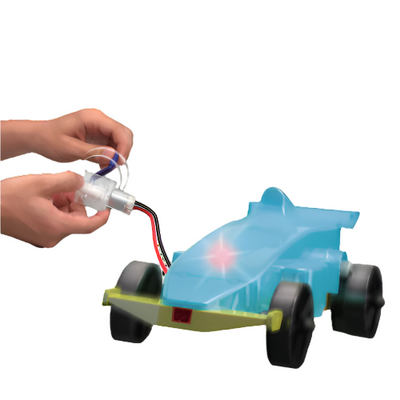Hands assembling a blue Kinetic Racer toy car with a hand crank generator to demonstrate sustainable energy and power an LED light.
