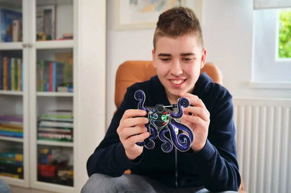Boy holding and playing with Wacky Robot Artemis mini robot kit with blinking LED lights