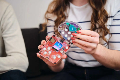 Woman holding and assembling Wacky Robot Buttons mini music-making robot kit with circuit board and buttons.