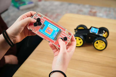 Hands holding a transparent remote control for Wheelson AI-powered self-driving robot car with the car blurred on a wooden table background