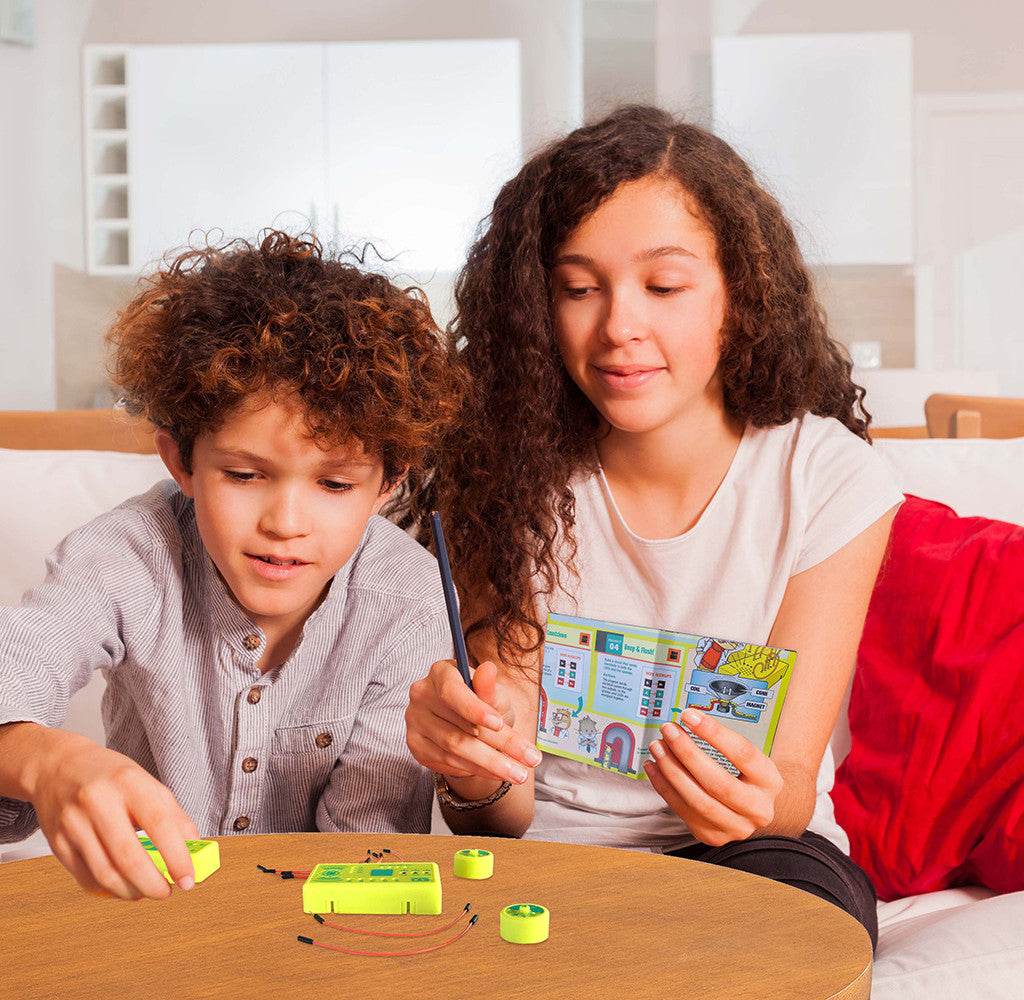 Children playing with Tiny Circuits mini-microprocessor electronics kit on a table