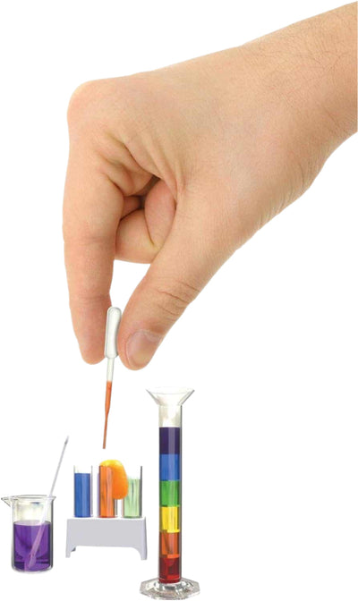 Hand holding dropper above miniature colorful beakers and test tubes from Tiny Science kit