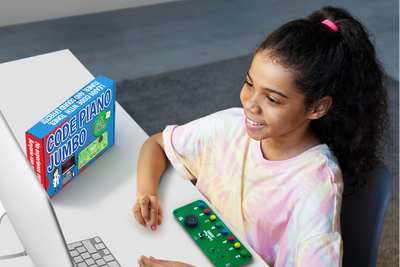 Child playing with the Code Piano Jumbo coding kit featuring jumbo buttons and a built-in speaker for learning programming through music.