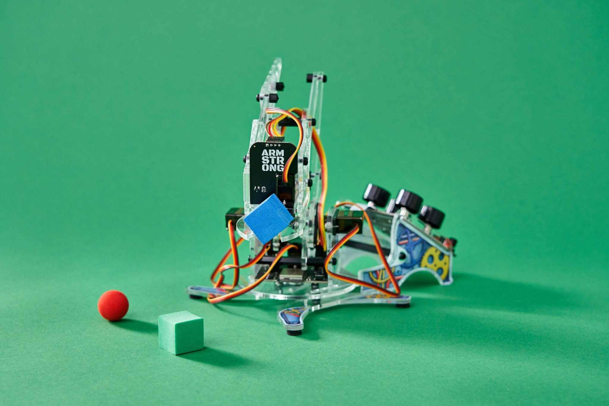 DIY robotic arm with color detection capability on a green background.
