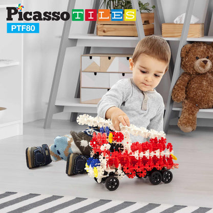 Child playing with PicassoTiles 800pc Building Chips set, constructing a colorful vehicle with wheels on the floor.