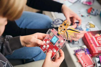 Child holding the Wacky Robot Mr. Bee mini robot DIY STEM kit with circuit board and bee design.